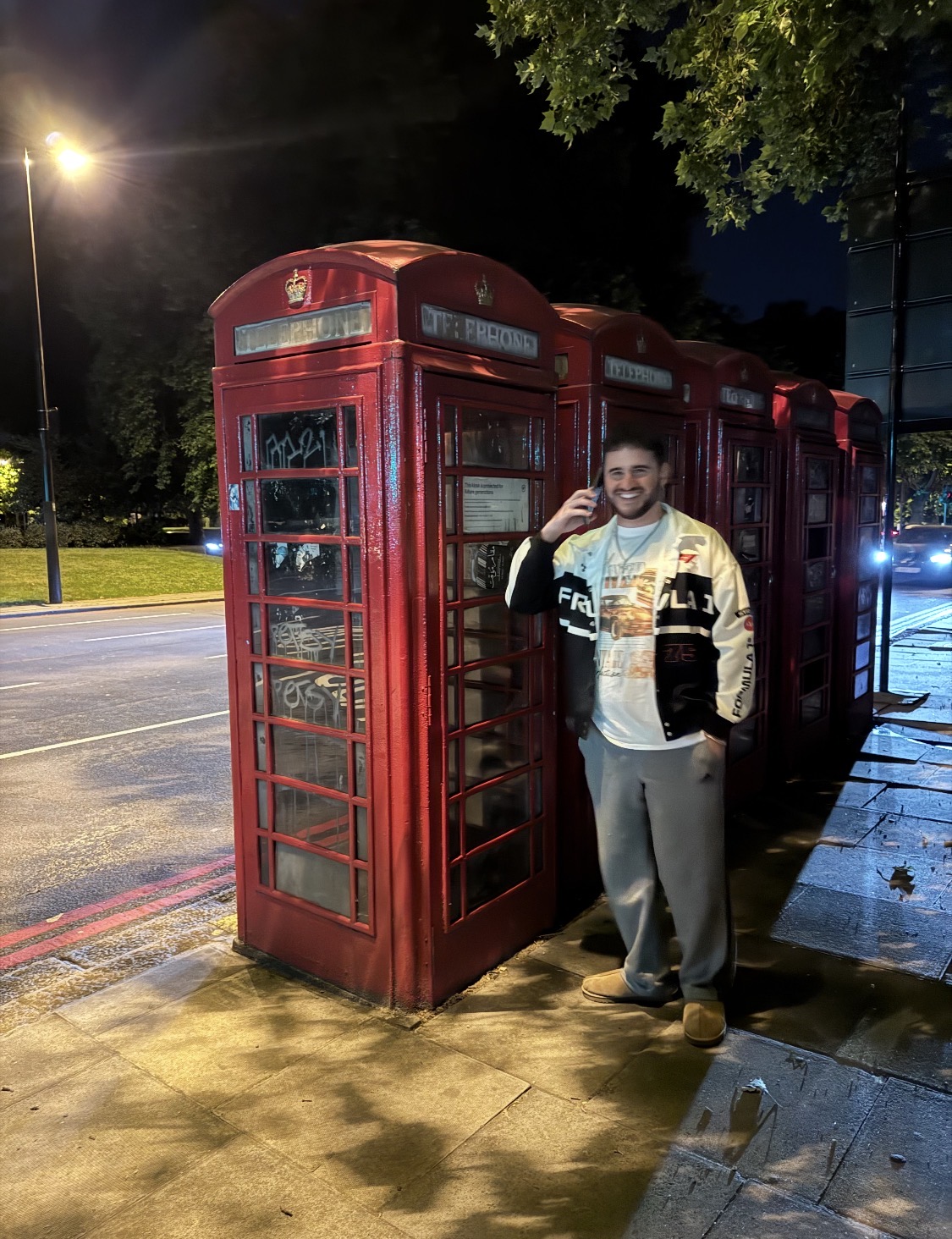 Imran, co-founder of Project Archie, standing beside red telephone boxes