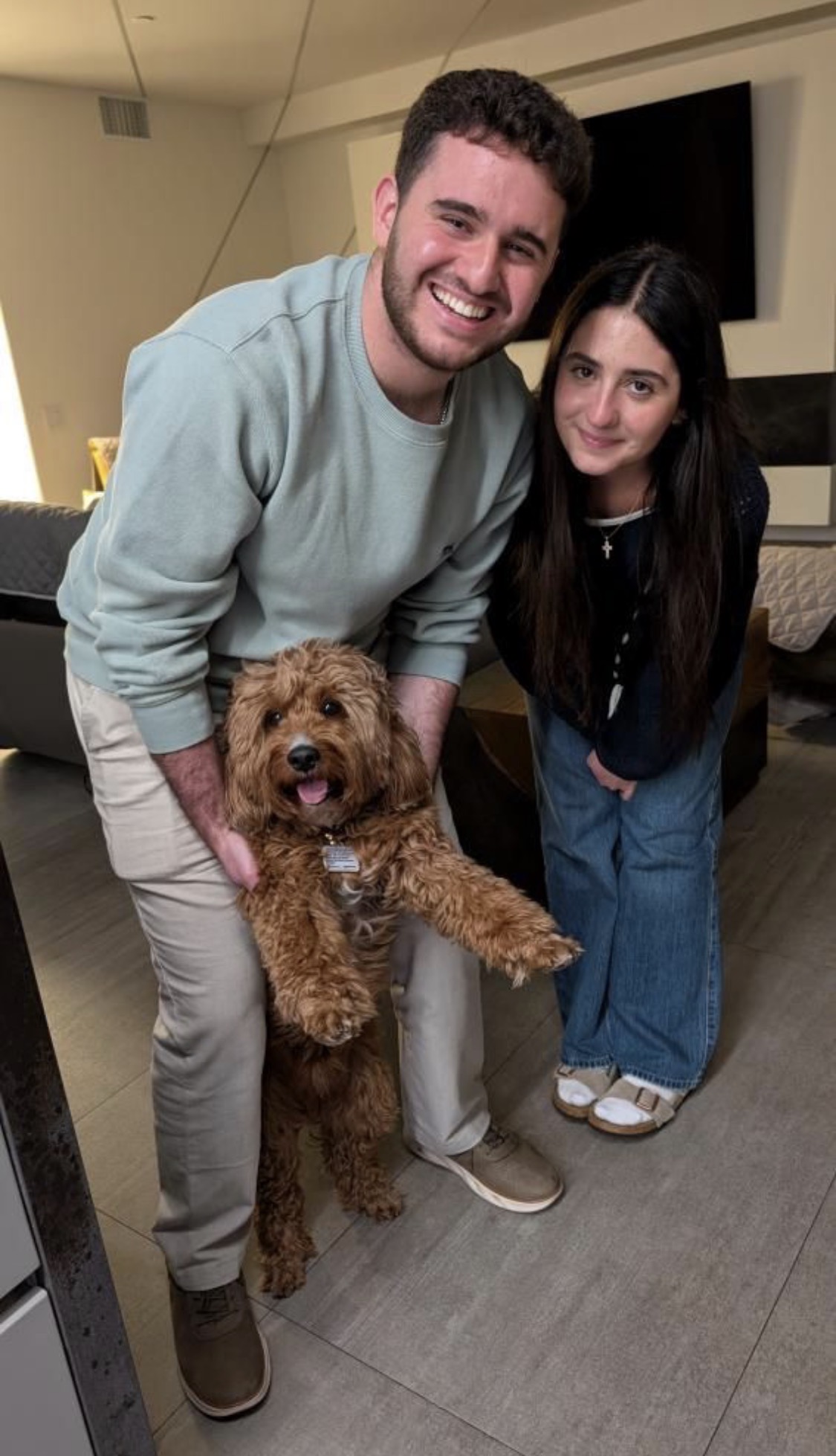 Imran and a friend holding Archie the Cavapoo, the dog who inspired Project Archie