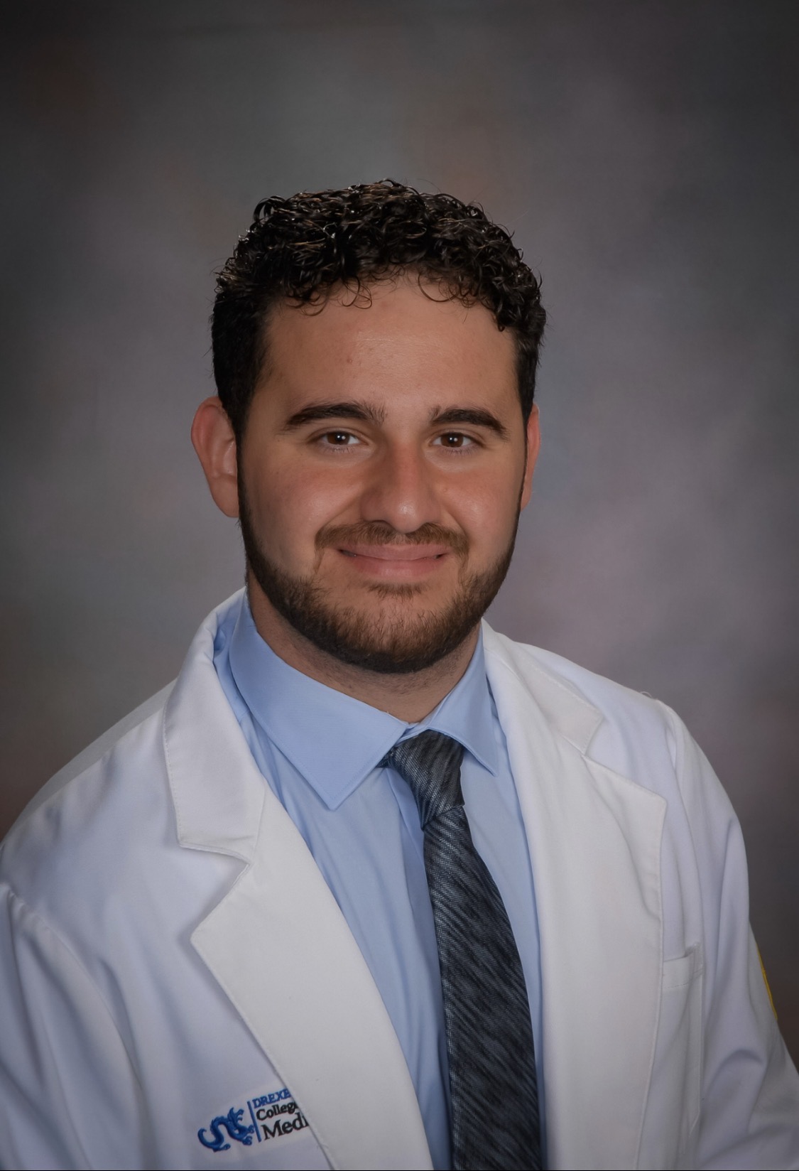 Imran, co-founder of Project Archie, in his medical school white coat