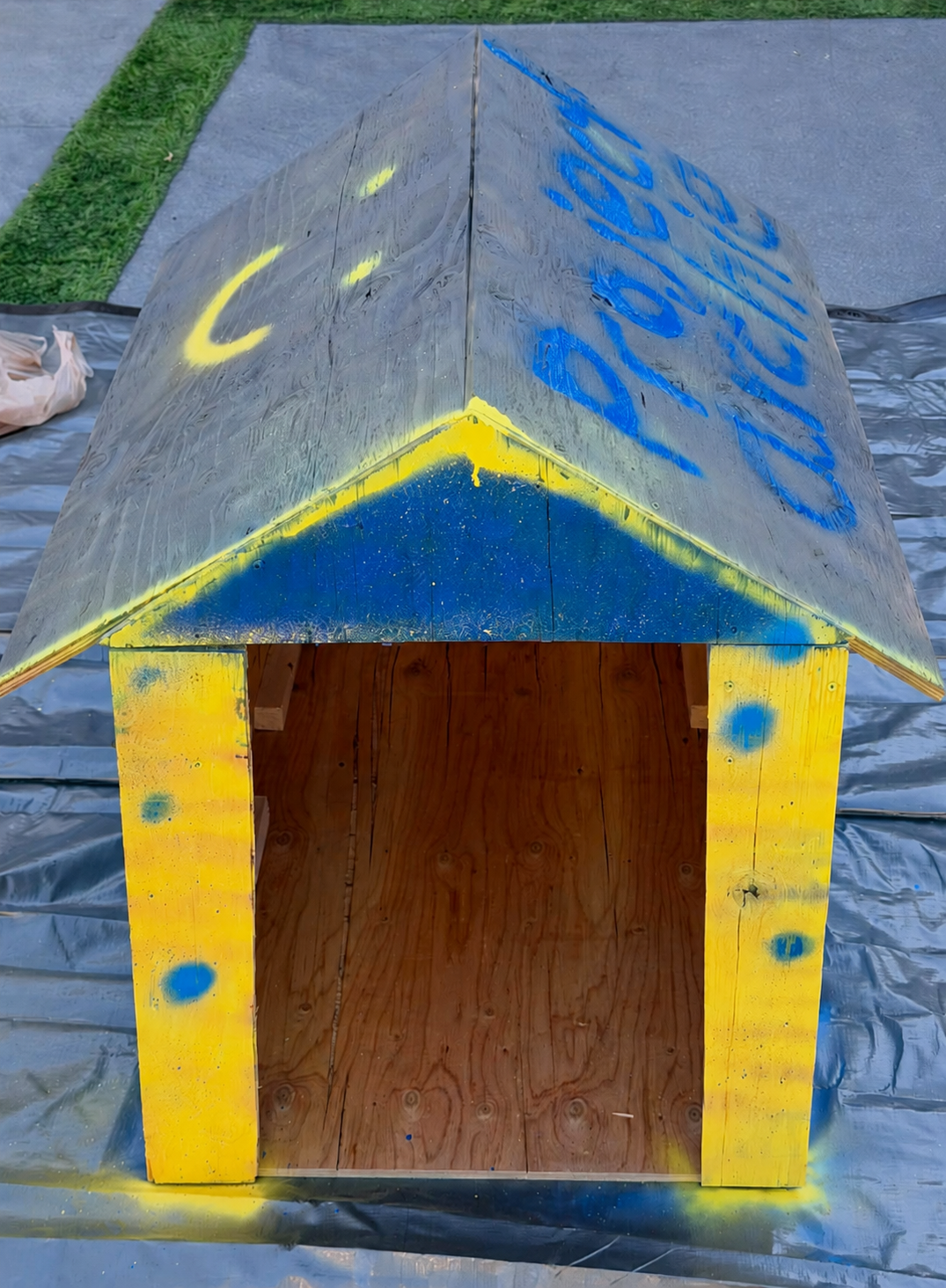 The first Project Archie doghouse prototype painted blue and yellow, proof of the impact students make for shelter dogs